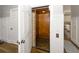 Interior shot of a home elevator with wood paneling and view of the Kitchen at 3013 Middle St, Sullivans Island, SC 29482