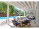 Inviting covered patio with dining and seating areas overlooking a sparkling pool at 3013 Middle St, Sullivans Island, SC 29482