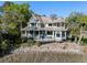 Stunning multi-story home boasting wraparound porches, mature landscaping, and waterfront views at 3104 Upda Creek, Seabrook Island, SC 29455
