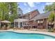 Large brick home featuring an outdoor kitchen, a screened-in porch, and a swimming pool in the backyard at 312 E Shepard Ln, Summerville, SC 29483