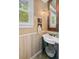 Bathroom with pedestal sink, wood paneling and decorative mirror at 312 E Shepard Ln, Summerville, SC 29483