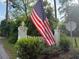 Charming entrance gate with white pillars, an American flag, and lush greenery at 312 E Shepard Ln, Summerville, SC 29483
