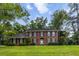 Charming brick home with symmetrical design, black shutters, well-manicured lawn, and mature trees at 312 E Shepard Ln, Summerville, SC 29483