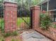 Charming garden gate with brick pillars and a wrought iron fence, accented by a blooming rose bush at 312 E Shepard Ln, Summerville, SC 29483