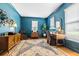 Stylish home office featuring rich blue walls, modern desk, and ample natural light at 312 E Shepard Ln, Summerville, SC 29483