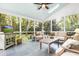 Bright sunroom with tile flooring, multiple seating areas, a ceiling fan, and natural light streaming through the many windows at 312 E Shepard Ln, Summerville, SC 29483