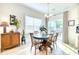 Light-filled dining area with a round table, chairs, and a cabinet, enhanced by a window view at 3208 Pecan Orchard Way, Charleston, SC 29414