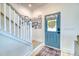 Bright entryway featuring a staircase, an accent wall adorned with pictures, and a stylish blue-colored front door at 3208 Pecan Orchard Way, Charleston, SC 29414