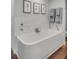 Bright bathroom features a soaking tub with marble backsplash, elegant fixtures, and rich wood flooring at 330 Concord St # 18F, Charleston, SC 29401