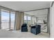 Serene bedroom featuring a plush bed, elegant blue chairs, and floor-to-ceiling windows with water views at 330 Concord St # 18F, Charleston, SC 29401