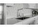 Close-up of a modern stainless steel kitchen sink and marble backsplash at 330 Concord St # 18F, Charleston, SC 29401