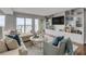 Cozy living room with built-in shelving, TV, and large windows with water views at 330 Concord St # 18F, Charleston, SC 29401