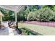 Spacious backyard with a privacy fence, lush greenery, and a covered patio at 3997 Aspera Dr, Summerville, SC 29483