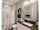 Well-lit bathroom featuring granite counters, decorative mirror, and a shower with patterned curtain at 3997 Aspera Dr, Summerville, SC 29483