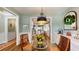 Bright dining area with a glass table and an elegant pendant light, adjacent to a modern, well-equipped kitchen at 3997 Aspera Dr, Summerville, SC 29483