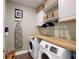 Laundry room with washer, dryer, butcher block countertop, storage cabinets and modern decor at 3997 Aspera Dr, Summerville, SC 29483