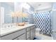 Stylish bathroom featuring double sinks, quartz countertop, and a blue patterned shower curtain creating a fresh, modern space at 413 Ribiero Dr, Summerville, SC 29486