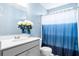 Bright bathroom featuring a single sink with gray cabinets, a mirror, and blue shower curtain, blending style and functionality at 413 Ribiero Dr, Summerville, SC 29486