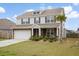 Attractive two-story home featuring a stone-accented front, attached garage, and green lawn at 413 Ribiero Dr, Summerville, SC 29486