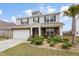 Elegant home with stone facade, manicured lawn, and a swaying palm tree at 413 Ribiero Dr, Summerville, SC 29486
