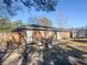 A brick home with an outdoor kitchen, grill, patio, and trampoline in the backyard under a sunny sky at 4437 Garwood Dr, Ladson, SC 29456