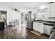 A dining area with white chairs, a stainless steel refrigerator, a window, and dark wood flooring at 4437 Garwood Dr, Ladson, SC 29456