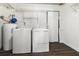 A laundry room with a washer, a dryer, a water heater, and dark wood flooring at 4437 Garwood Dr, Ladson, SC 29456