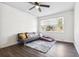 A living room with a futon, an area rug, a ceiling fan, a window, and dark wood flooring at 4437 Garwood Dr, Ladson, SC 29456