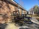 A patio featuring a metal outdoor dining table with six chairs is situated outside the red brick of the home at 4437 Garwood Dr, Ladson, SC 29456