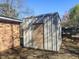 A metal shed with a door sits next to a brick building near a fence at 4437 Garwood Dr, Ladson, SC 29456