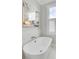 Close-up of a modern white soaking tub with stylish faucet and bright window at 49 Ashley Ave, Charleston, SC 29401
