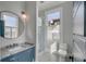 Modern bathroom with stylish blue vanity, round mirror, glass-enclosed shower, and toilet near a sunlit window at 49 Ashley Ave, Charleston, SC 29401