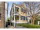 Charming two-story home with yellow siding, black shutters, and a double porch at 49 Ashley Ave, Charleston, SC 29401