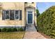 Inviting home exterior with a blue front door, gray stairs, manicured bushes, and brick pathway at 49 Ashley Ave, Charleston, SC 29401