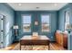 Serene blue home office with view, featuring hardwood floors, bright windows and handsome wooden furniture at 49 Ashley Ave, Charleston, SC 29401