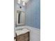 Stylish powder room with patterned wallpaper, marble countertop vanity at 49 Ashley Ave, Charleston, SC 29401