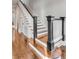 Elegant staircase with dark wood floors, white risers and banisters, and dark handrail at 49 Ashley Ave, Charleston, SC 29401