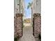 Charming walkway between houses with gravel path and brick pillars leading to a lush garden at 49 Ashley Ave, Charleston, SC 29401