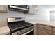 A modern range and microwave oven are shown with stainless steel finishes and light grey cabinets at 551 Gahagan Rd, Summerville, SC 29486