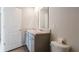 Bright bathroom featuring double sinks, gray cabinetry, and wood-look flooring, creating a modern and functional space at 553 Gahagan Rd, Summerville, SC 29486