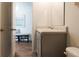 Bathroom featuring a gray vanity, sink, toilet and doorway to the hallway at 555 Gahagan Rd, Summerville, SC 29486