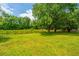 Lush backyard with green grass, framed by a fence, and mature trees adding shade and privacy at 5823 Lakeview Dr, Hanahan, SC 29410