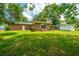 Picturesque backyard featuring a brick home with a spacious lawn, screened porch and lush green trees at 5823 Lakeview Dr, Hanahan, SC 29410
