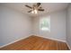 A cozy bedroom featuring a ceiling fan with lighting and hardwood flooring at 5823 Lakeview Dr, Hanahan, SC 29410