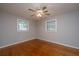 A well-lit bedroom shows neutral walls and wood floors under a ceiling fan at 5823 Lakeview Dr, Hanahan, SC 29410