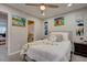 Bedroom with a ceiling fan, bed with decorative pillows and throw, artwork, and a door to the bathroom at 6279 Lucille Dr # B, North Charleston, SC 29406