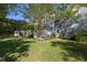 Well-manicured backyard featuring a deck, green lawn, and mature trees offering privacy and shade at 700 Preservation Pl, Mount Pleasant, SC 29464