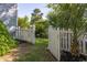 Backyard access through a white picket fence leading to a beautifully landscaped garden at 700 Preservation Pl, Mount Pleasant, SC 29464