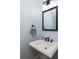 Charming powder room features a pedestal sink, vintage mirror, and updated lighting at 700 Preservation Pl, Mount Pleasant, SC 29464
