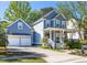 Charming two-story home with a blue exterior, inviting front porch, and well-maintained landscaping at 700 Preservation Pl, Mount Pleasant, SC 29464